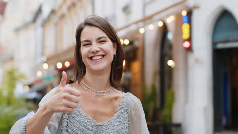 Happy-woman-showing-thumbs-up,-like-sign-positive-something-good-positive-feedback-in-city-street