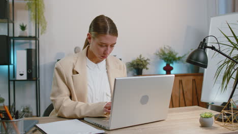 Businesswoman-working-on-office-laptop-pointing-to-camera-looking-happy-expression,-making-choice