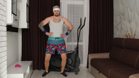 Funny-man-athlete-sportsman-with-beard-makes-workout-stretching-exercises,-practicing-sport-at-home