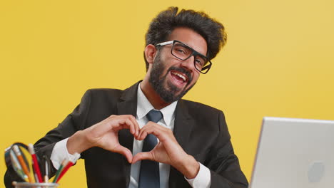 Indian-business-man-makes-symbol-of-love,-showing-heart-sign-to-camera,-express-romantic-feelings