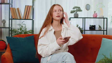 Una-Chica-Sentada-En-Un-Sofá-Usando-Un-Teléfono-Inteligente-Comparte-Mensajes-En-Aplicaciones-De-Redes-Sociales-Viendo-Películas