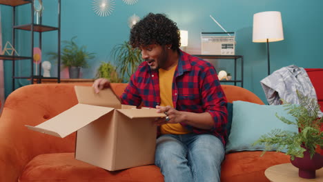 Glücklicher-Indischer-Mann,-Der-Den-Karton-Auspackt,-Lieferung-Von-Paketen,-Online-Shopping-Kauf-Zu-Hause