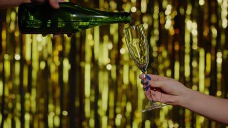 Alkoholisches-Champagnergetränk-Wird-In-Zeitlupe-Aus-Der-Flasche-In-Ein-Trinkglas-Auf-Goldenem-Hintergrund-Gegossen