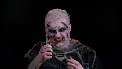 Zombie-Unheimlicher-Toter-Halloween-Mann-Mit-Blutigem-Messer,-Der-Versucht,-Im-Dunklen-Studioraum-Zu-Erschrecken-Und-Zu-Töten