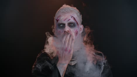 Unheimlicher-Mann-Halloween-Zombie-Mit-Blutigem-Gesicht-Bläst-Rauch-Aus-Nase-Und-Mund-Und-Lässt-Die-Luft-Küssen