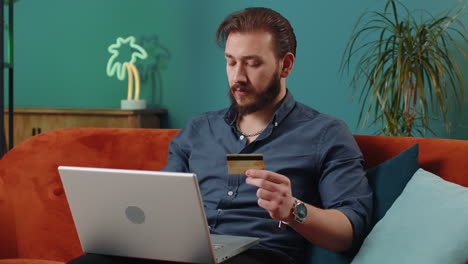Junger-Libanesischer-Mann-Benutzt-Kreditkarte-Und-Laptop,-überweist-Geld-Und-Kauft-Online-Ein