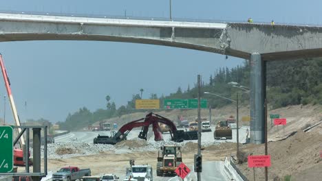 Excavators-dig-near-an-empty-stretch-of-the-405-freeway-in-Los-Angles-as-crews-tear-down-part-of-a-bridge