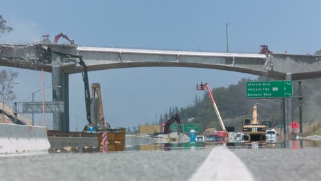 Wide-view-of-heavy-equipment-tearing-down-part-of-a-bridge-over-the-405-freeway-in-Los-Angles-1