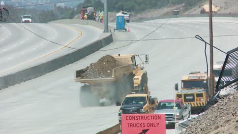 Dump-trucks-haul-earth-away-from-an-empty-stretch-of-the-405-freeway-in-Los-Angles-as-crews-tear-down-part-of-a-bridge