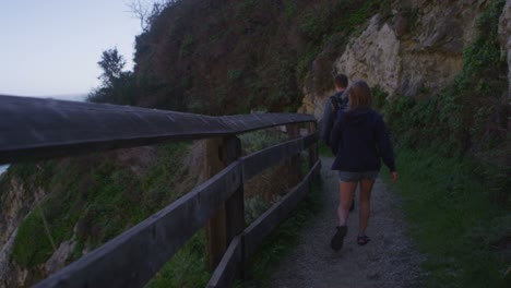 A-couple-walk-along-a-path-on-a-sea-cliff-1