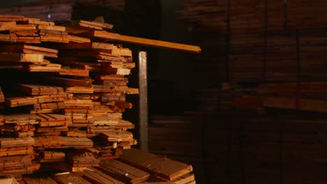 Pan-right-across-wood-planks-stacked-in-a-workshop-1