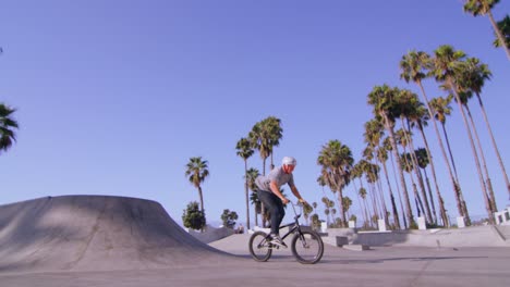 Low-angle-view-of-a-BMX-bike-rider-executing-a-jump-and-turn-at-a-skatepark