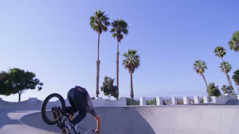 A-BMX-bike-rider-does-a-jump-and-rides-the-wall-at-a-skatepark