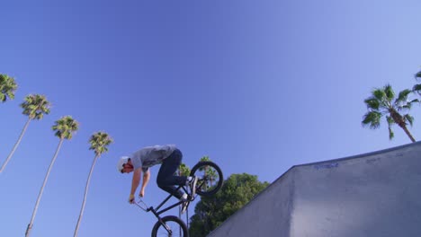 Low-angle-view-of-a-BMX-bike-rider-executing-a-jump-at-a-skatepark-1