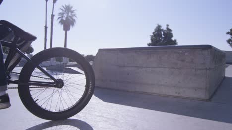 A-BMX-bike-rider-peddles-out-of-frame-at-a-skatepark