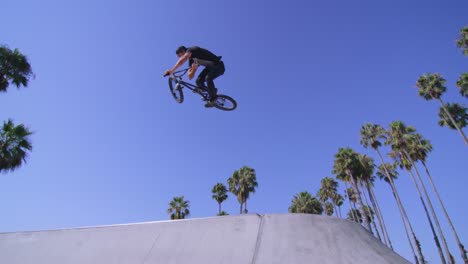 Low-angle-view-of-a-BMX-bike-rider-executing-a-jump-at-a-skatepark-3