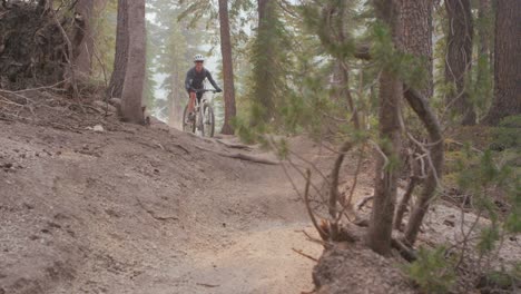 A-mountain-biker-rides-on-a-dirt-path-in-a-forest