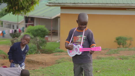 An-african-boy-plays-a-pink-guitar-in-Uganda