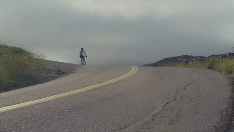 Slow-motion-shot-of-mountain-bike-rider-moving-along-California-highway-1