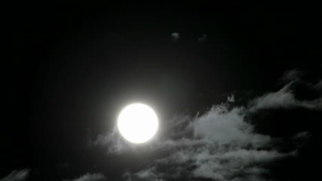 Una-Luna-Llena-Brillante-Se-Eleva-Sobre-Las-Nubes-Que-Se-Mueven-Rápidamente-En-El-Cielo-Nocturno