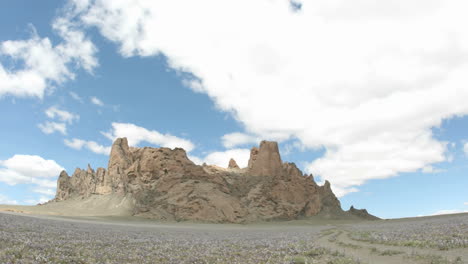 Sunlight-reflects-in-patches-as-fluffy-white-clouds-pass-over-New-Mexico's-Shiprock