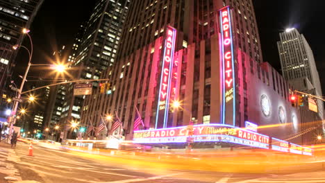 Pink-and-gold-lights-merge-in-an-accelerated-shot-of-traffic-passing-in-front-of-Radio-City-Music-Hall-at-night