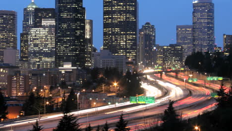 As-the-goldenhour-darkens-into-night-accelerated-traffic-blurs-into-streaks-of-light-before-an-illuminated-Seattle-skyline