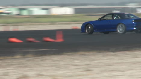 A-Blue-Car-Squeals-Its-Tires-As-It-Is-Skillfully-Guided-Through-A-Drifting-Course-In-At-Camarillo-Airport-In-Camarillo-California