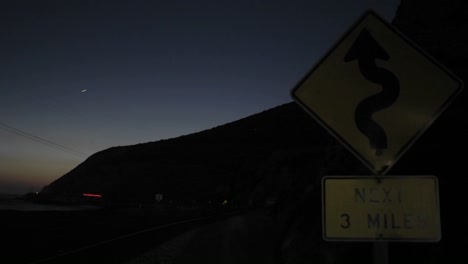 A-Time-Lapse-Shot-Of-Traffic-At-Night-Passing-A-Roadsign