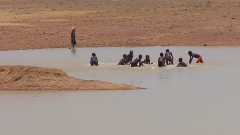 Kinder-Verwenden-Konische-Netze,-Um-Fische-In-Einem-Pool-Entlang-Eines-Flusses-In-Mali-Afrika-Zu-Fangen