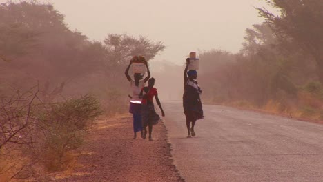 Women-walk-carrying-goods-on-their-heads-through-the-Sahara-desert-in-mali