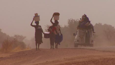 Women-walk-carrying-goods-on-their-heads-through-the-Sahara-desert-in-mali-2