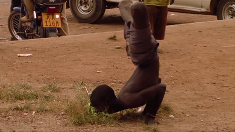 An-African-man-does-a-bizarre-rap-dance-with-his-legs-crossed-in-a-small-village