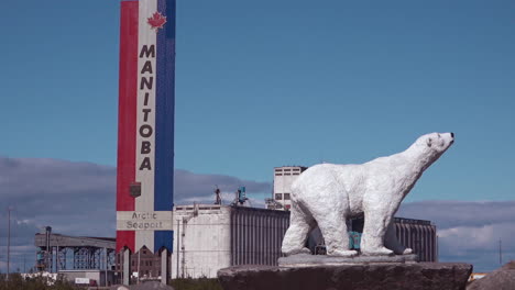 Polar-bear-statue-stands-near-a-sign-advertising-Churchill-Manitoba-Canada