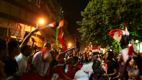 Los-Manifestantes-Ondean-Banderas-Y-Se-Disparan-Fuegos-Artificiales-En-Un-Mitin-Nocturno-En-El-Cairo,-Egipto-2