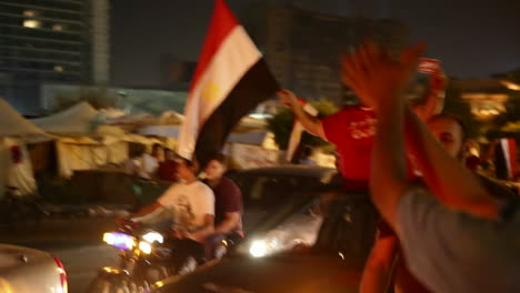 Un-Hombre-Agita-Una-Bandera-Desde-Un-Coche-En-Un-Mitin-Nocturno-En-El-Cairo,-Egipto