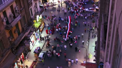 Overhead-view-of-protestors-march-and-carry-banners-in-the-streets-of-Cairo-Egypt-at-night