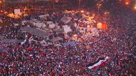 Vista-Aérea-Como-Manifestantes-Jam-Tahrir-Square-En-El-Cairo,-Egipto,-En-Un-Gran-Mitin-Nocturno