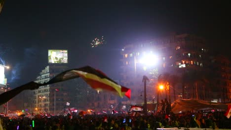 Vista-Desde-El-Suelo-Mientras-Los-Manifestantes-Cantan-Y-Ondean-Banderas-En-Un-Gran-Mitin-Nocturno-En-La-Plaza-Tahrir-En-El-Cairo,-Egipto-2