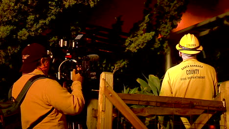 A-News-Crew-Films-As-A-Firefighter-Tries-To-Save-A-Burning-House-During-The-Holiday-Fire-In-Goleta-California