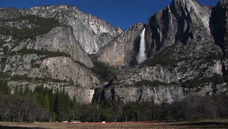 Rocky-Mountains-Verfügen-über-Einen-Wasserfall-Und-Verkehr-Am-Fuße-Der-Berge
