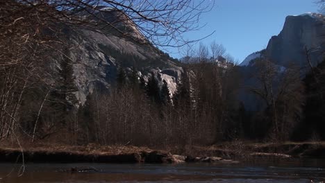 A-Look-At-Bare-Trees-And-Rocks-With-A-Stream-Rushing-Through-The-Foreground