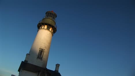 A-Handheld-Jaunty-View-Of-A-Lighthouse-With-Sunlight-On-Its-White-Tower