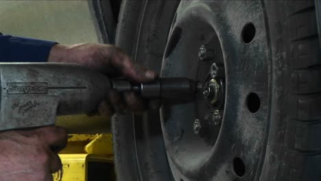 A-Mechanic-Tightens-Lugnuts-With-A-Power-Tool-In-This-Closeup