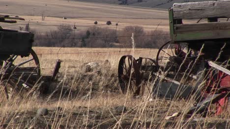 Broken-And-Abandoned-Farm-Machinery-Rest-In-A-Field-That-Overlooks-The-Dry-Prairie-Beyond