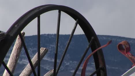 Camera-Looks-At-Mountains-Through-The-Spokes-Of-Abandoned-Wagon-Wheels