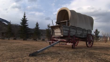A-Covered-Wagon-Looks-Right-At-Home-Against-The-Backdrop-Of-Evergreens-And-Prairie