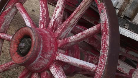 A-Worn-Covered-Wagon-Wheel-Shows-The-Remains-Of-Its-Original-Red-Paint