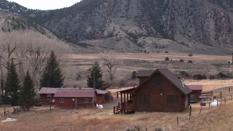 A-Rural-Homestead-Sits-At-The-Foot-Of-A-Mountain-Range