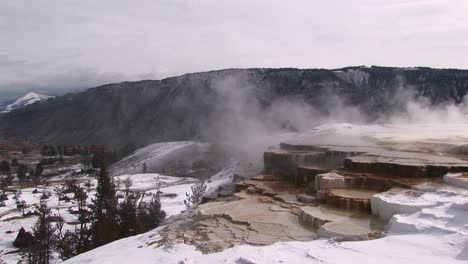 A-Look-At-Hot-Springs'-Limestone-Terraces-In-Winter-With-Scenic-Mountains-In-The-Background